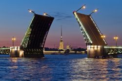 Una fotografia classica delle notti bianche di San Pietroburgo: sulle spettacolari rive del fiume Neva con un ponte mobile aperto e, sullo sfondo, la Fortezza di Pietro e Paolo, una delle icone ...