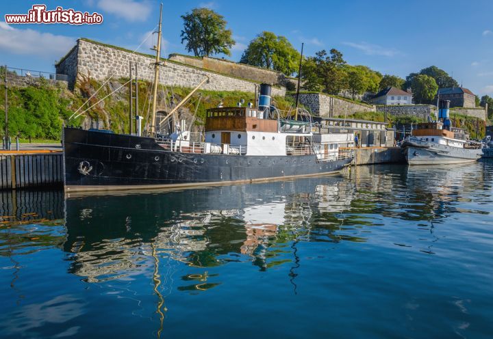 Immagine Una vecchia barca sul fiordo a fianco del castello di Akershus ad Oslo - © Anna Jedynak / Shutterstock.com