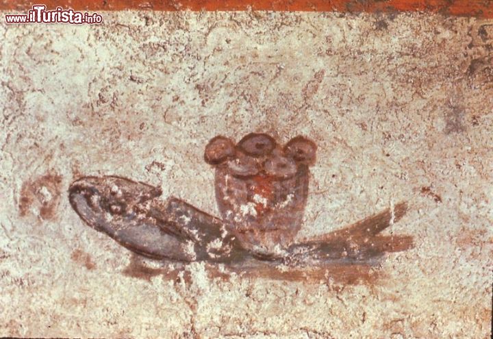 Immagine Un pane ed un pesce ecauristico , uno degli affreschi che si possono vedere durante la visita alle Catacombe di San Callisto a Roma - © Wikimedia Commons.