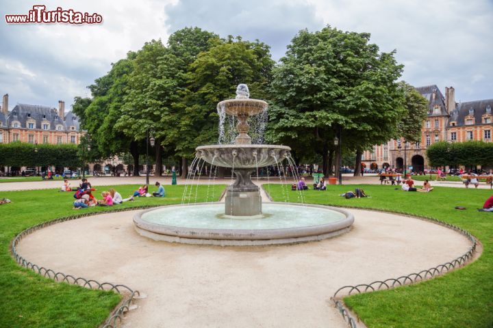 Immagine Scorcio di una fontana a Place des Vosges a Parigi. I francesi si rilassano molto volentieri in questa piazza, nelle calde giornate di primavera ed in estate - © Christian Mueller / Shutterstock.com