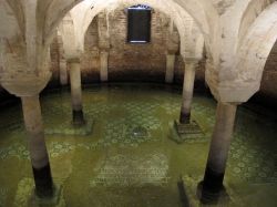 La cripta della Basilica di San Francesco a Ravenna è parzialmente allagata per il fenomeno della subsidenza. I turisti sono soliti a gettare monetine votive sul pavimento a mosaico dove ...