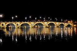 Tolosa, Francia: una foto notturna con il Pont Neuf illuminato che si riflette nelle acque della Garonna. Il fiume nasce sui Pirenei spagnoli e sfocia nell'Atlantico a nord di Bordeaux.