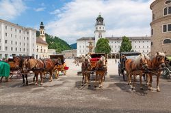 Le carrozze dei cavalli attendono i turisti in piazza della Residenza a Salisburgo - © aldorado / Shutterstock.com