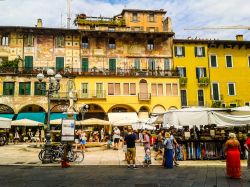 Turisti al mercato in Piazza delle Erbe a Verona, una delle piazze più conosciute a fotografate d'Italia - © Claudio Divizia / Shutterstock.com