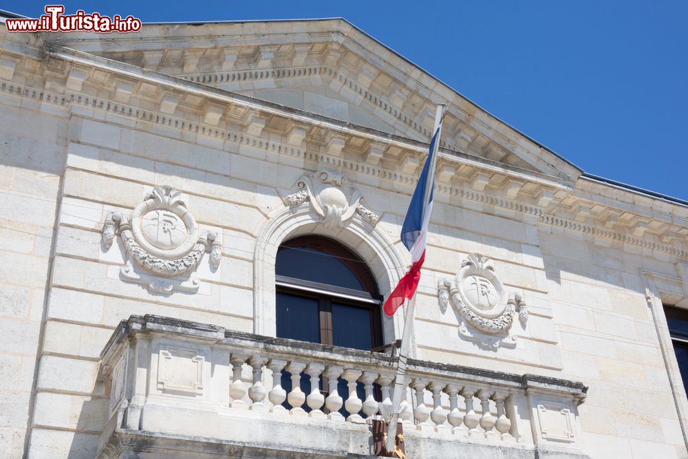 Immagine La bandiera francese sventola dal balcone dell'Hotel de Ville di Parigi, Francia. Il tricolore nacque negli anni della rivoluzione francese. Il vessillo nazionale è formato dai colori della città di Parigi (blu e rosso) e da quello della casata Borbone (bianco).