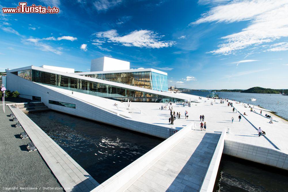 Immagine Una suggestiva veduta della National Oslo Opera House, Norvegia. Il tetto dell'edificio fa un angolo al livello del suolo e invita le persone a camminarvi sopra sino a raggiungere la sommità da cui si può ammirare il panorama sulla città - © Nanisimova / Shutterstock.com