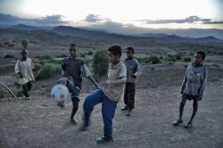Etiopia bambini giocano a palla lungo strada ...