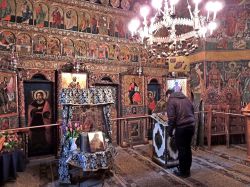 Interno del monastero di Voronet in Romania, con una persona in preghiera - © Monia Savioli