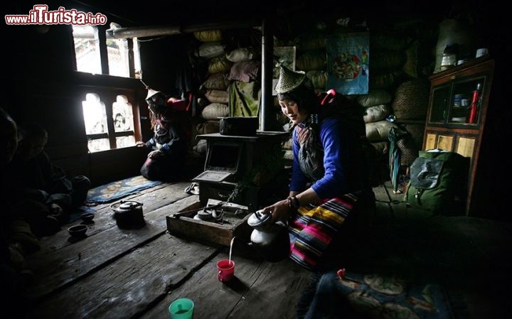 Donna serve il The in una casa tradizionale a Laya, siamo in Bhutan uno degli stati più belli dell'Asia - ©  www.tpoty.com - Foto di Tim Allen