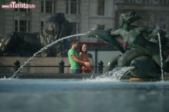 Immagine Turisti a Trafalgar Square, a fianco di una delle fontane di questa famosa piazza, nel cuore di Londra - © James McCormick / www.visitlondon.com/it