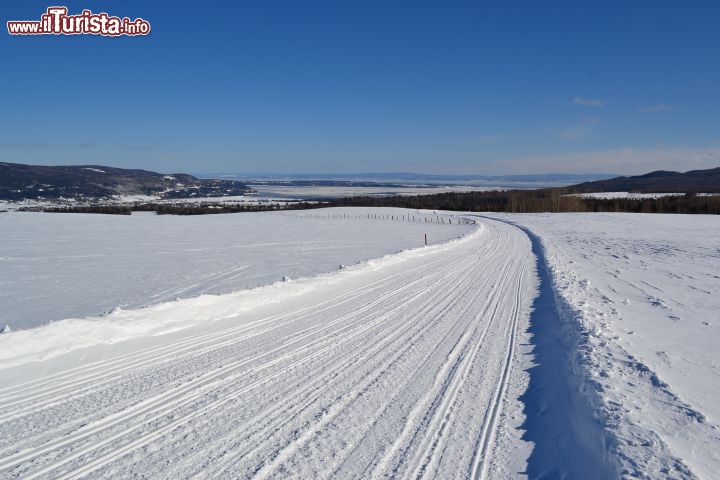 Immagine Sentiero per motoslitta: si trova a Baie-Saint-Paul, nella regione dello Charlevoix, e sullo sfondo si possono vedere le acque gelate del fiume Saint-Laurent. I sentieri sono tracciati ogni anno dai volontari iscritti ai motoclub.