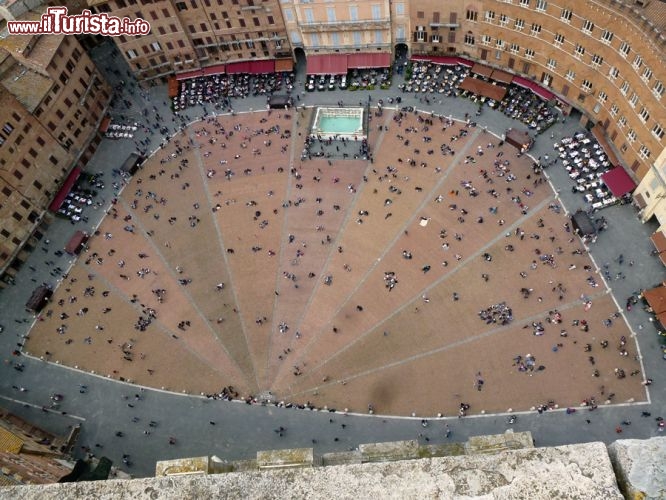 Immagine La particolare forma a conchiglia di Piazza del Campo, vista dalla cima della Torre del Mangia. Nella foto è possibile notare la divisione in 9 settori della piazza, la cui una circonferenza è di 333 metri. In alto al centro la Fonte Gaia