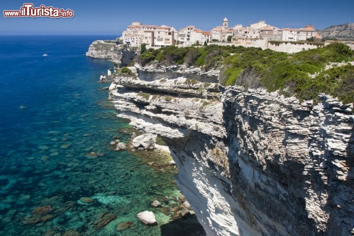 Le scogliere di Bonifacio in Corsica - Un vero e proprio fiordo accoglie le splendide scogliere di Bonifacio, nel sud della Corsica: giganti di calcare bianco che si tuffano a picco nel Tirreno, visibili anche ad occhio nudo dal nord della Sardegna nelle giornate più terse. In cima alle scogliere qualche sentiero si snoda tra la macchia, accompagnandovi in una suggestiva passeggiata in mezzo al mirto, e tutt’intorno un panorama azzurro, blu e turchese confonde le idee sui limiti di cielo e mare. Dopo il trekking concedetevi una gita in barca tra le falesie e i faraglioni, per apprezzare le scogliere da un altro punto di vista, senza dimenticare un’esplorazione del porto di Bonifacio, inserito tra le pareti rocciose come fosse una perla naturale. È da qui che partono in traghetti per Santa Teresa di Gallura (OT), in Corsica, a solo 12 km di distanza  - © Caroline Devulder / Shutterstock.com 