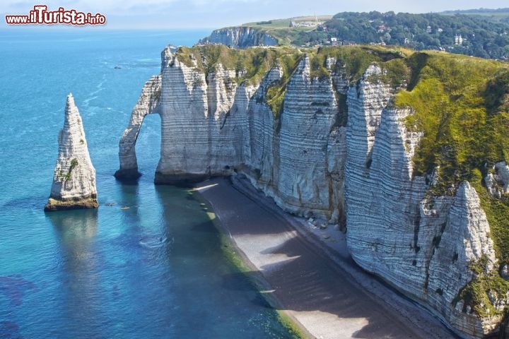 Etretat nel nord della Francia - Che la Normandia riservi panorami da sogno non è una novità, e il piccolo villaggio di pescatori di Etretat ne è la conferma, con la sua spiaggia di ciottoli lisci vegliata da imponenti scogliere bianche. Le falesie più famose sono quella d’Amont, raggiungibile grazie a un ripido sentiero panoramico e sormontata dalla Cappella di Notre Dame de la Garde, e quella d’Avel, servita da una lunga scalinata che approda a un incantevole belvedere. Dalla falesia d’Avel parte il magnifico arco naturale di Manneporte, che disegna una bella architettura di roccia contro il cielo, e dietro di esso si innalza il grandioso scoglio de l’Aiguille, alto ben 70 metri. Gustave Courbet e Claude Monet si lasciavano volentieri ammaliare da questi luoghi selvaggi.
Etretat si trova circa 200 km a nord-ovest di Parigi, da cui è raggiungibile in auto mediante la A13 oppure in treno  - © Alexander Cherednichenko / Shutterstock.com 